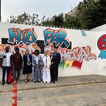Members of the delegation with Ambassador Mounier in front of the wall commemorating 60 years of bilateral relations between Canada and Senegal, with the artists who painted it. | Les membres de la délégation en compagnie de l'Ambassadeure Mounier devant le mur commémoratif des 60 ans de relations bilatérales entre le Canada et le Sénégal, avec les artistes qui ont réalisé l'oeuvre.
