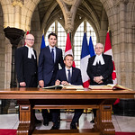 S.E. Emmanuel Macron, président de la République française, signant les Livres des visiteurs de marque au Parlement du Canada en présence du PM canadien, Justin Trudeau, du Président du Sénat, George Furey, et du Président de la Chambre des communes, Geoff Regan. Le 6 juin 2018.